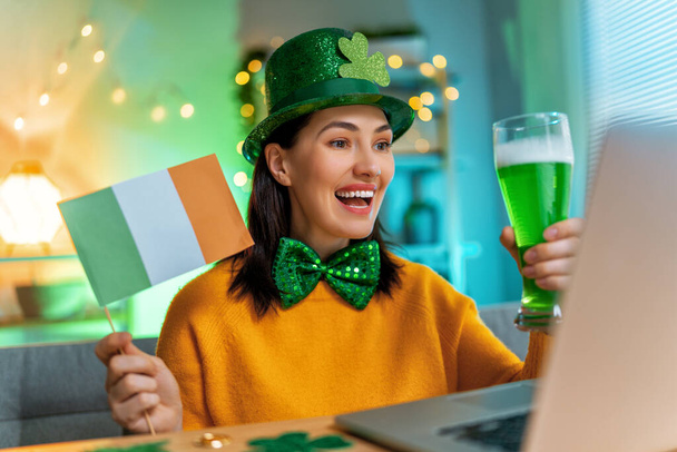 Happy woman celebrating St. Patrick's Day with her friends by online at home. - Fotó, kép
