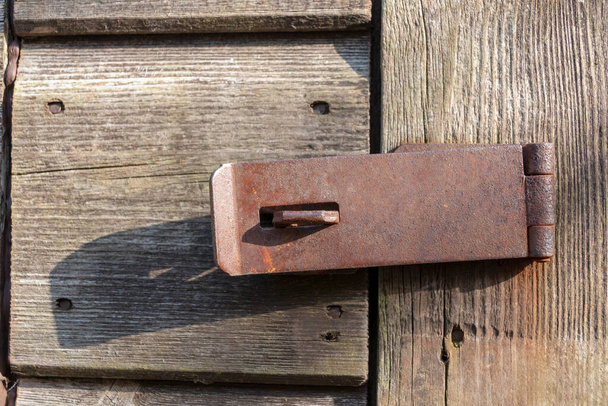 a close up view of a open lock that keeps this wooden door closed  - Photo, Image