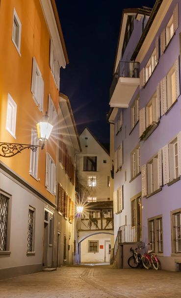 Ulice średniowiecznego miasta Chur, które jest również najstarszym miastem w Szwajcarii, w niebieskiej godzinie - Zdjęcie, obraz