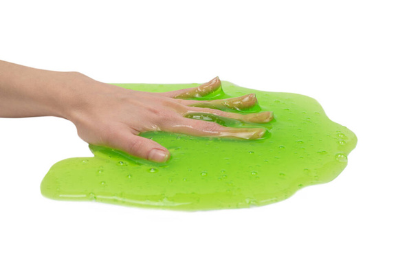Grünes Schleimspielzeug in Frauenhand isoliert auf weißem Hintergrund. - Foto, Bild