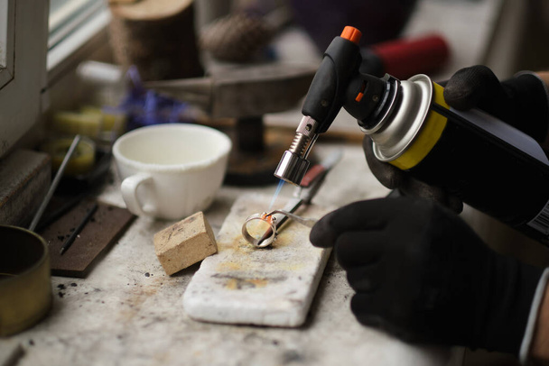 Fabrication de bijoux artisanaux avec des outils professionnels. Un processus de bijoutier fait à la main, la fabrication de bijoux. Fonte du métal - Photo, image