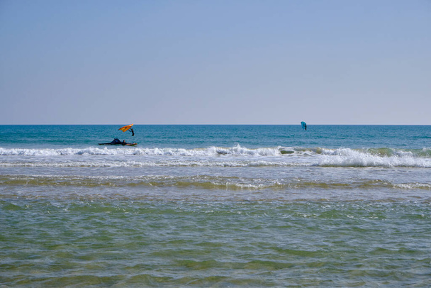 Włochy, Sycylia, Morze Śródziemne, Marina di Ragusa (prowincja Ragusa); surferzy w morzu - Zdjęcie, obraz