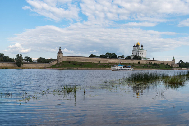 Plezierboot op de rivier de Velikaya tegenover de Trinity kathedraal in Pskov Krom (Kremlin). Rusland - Foto, afbeelding