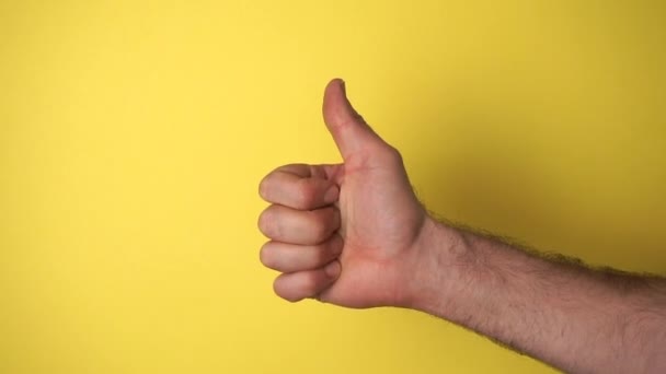 Male hand makes Like on a blank colored background. Quality, luck, approval, success concept. - Footage, Video