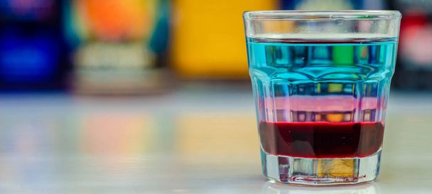 Uma bebida colorida em camadas tiro em um bar preparado pelo barman, tempo de festa - Foto, Imagem
