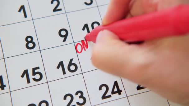 Close-up Womans hand van het schrijven van ONLINE EXAM op witte kalender boord. - Video