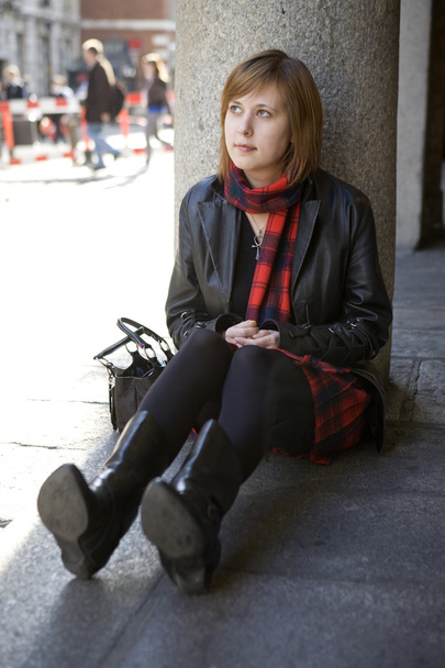 chica atractiva joven con el pelo rojo sentado en la calle, esperando
.  - Foto, imagen