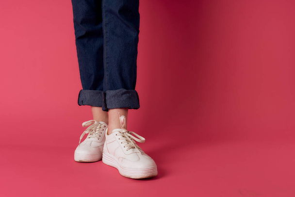 Pies femeninos zapatillas blancas calle moda rosa fondo - Foto, imagen