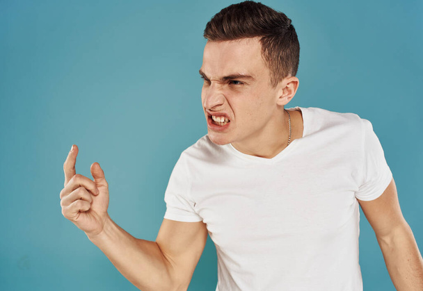 El tipo sobre un fondo azul gestos con sus manos modelo de agresión estrés Victoria - Foto, imagen