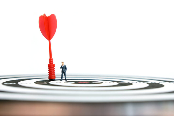 Business strategy conceptual photo - Miniature businessman with red arrow on a dartboard - Photo, Image