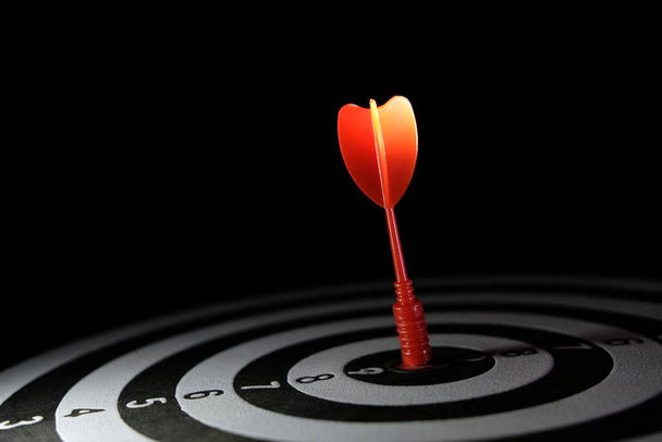 İş stratejisinin kavramsal fotoğrafı / doğruluğu - hedef dart tahtasının tam ortasına saplanmış kırmızı bir ok - Fotoğraf, Görsel