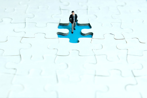 Business strategy conceptual photo - miniature businessman walking inside missing piece of puzzle - Photo, Image