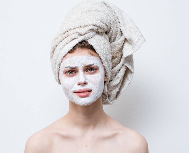 nude woman with white cream on her face and a towel on her head - Foto, immagini