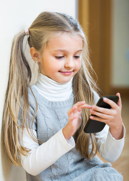 Little girl with cell phone indoors. - Foto, Bild