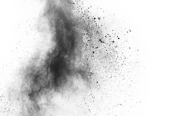 deeltjes houtskool op witte achtergrond, abstract poeder gespoten op witte achtergrond, Freeze beweging van zwart poeder exploderen of gooien zwart poeder. - Foto, afbeelding