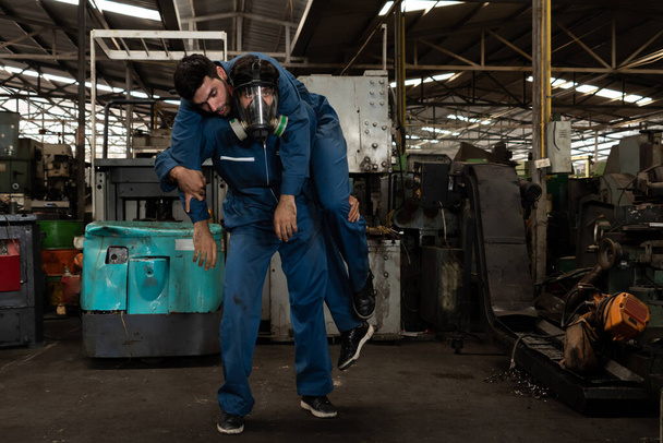 Yetenekli bir fabrika işçisi, takım arkadaşını zehirli gaz sızıntısından kurtarır. - Fotoğraf, Görsel