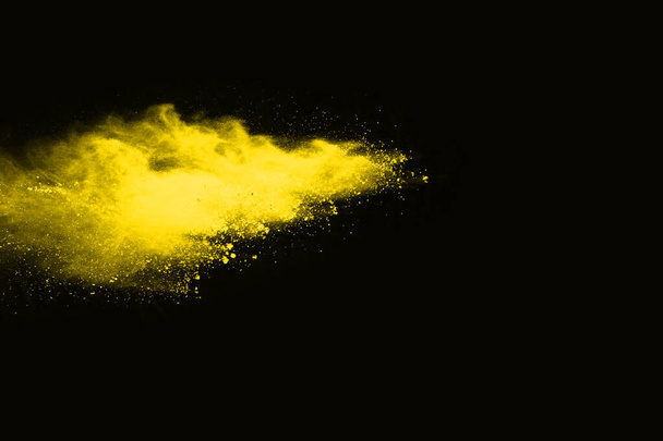 Explosión de polvo amarillo sobre fondo negro. Nube de colores. El polvo colorido explota. Pintura Holi. - Foto, Imagen