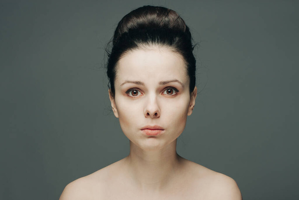 woman with bare shoulders clear skin collected hair emotions - Photo, Image