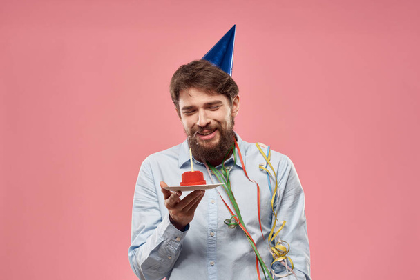 Bir adam bir tabakta pasta tutuyor ve yukarıdan izole edilmiş bir arkaplan mumu. - Fotoğraf, Görsel