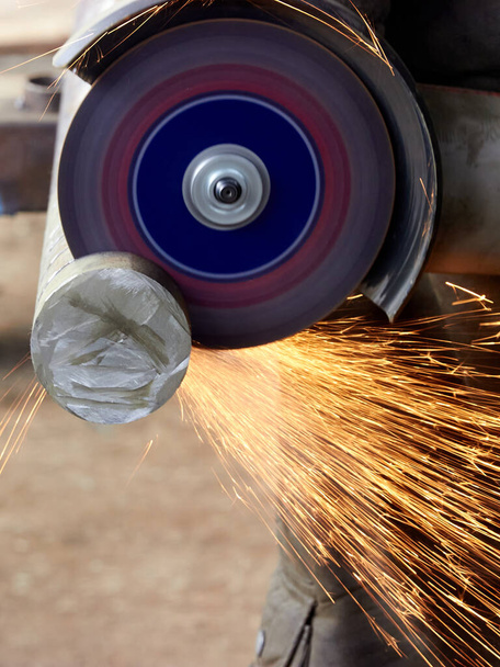 різання круглої металевої плити з кутовою шліфувальною машиною
 - Фото, зображення