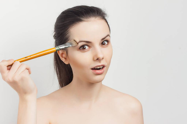 bonita mujer aplicando crema de cepillo en la cara rejuvenecimiento del cuidado de la piel - Foto, Imagen