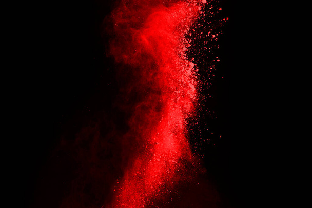 abstract red powder explosion on black background.abstract red powder splatted on black background. Freeze motion of red powder exploding. - Photo, Image