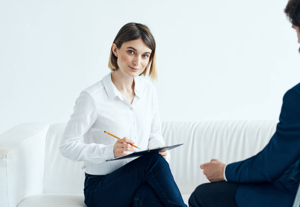 Una donna con documenti ascolta i problemi di un uomo su uno psicologo di sfondo leggero - Foto, immagini