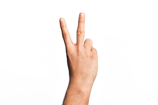 Hand eines kaukasischen jungen Mannes mit Fingern über isoliertem weißem Hintergrund, der die Zahl 2 zählt, die zwei Finger zeigt, Sieg und Siegersymbol gestikuliert - Foto, Bild