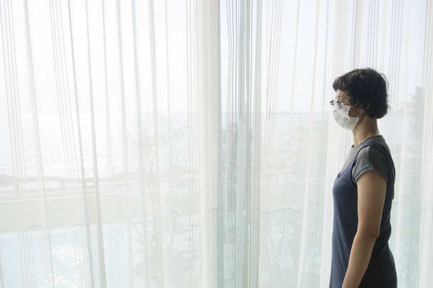 Азиатские туристки носят серую одежду, очки и маски для лица в Государственном карантине. - Фото, изображение