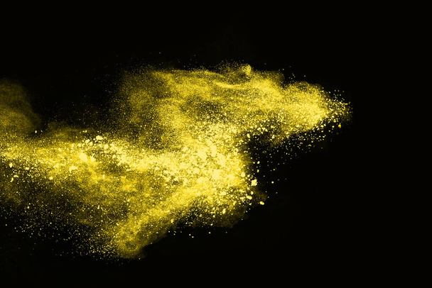 Explosión de polvo amarillo sobre fondo negro. Nube de colores. El polvo colorido explota. Pintura Holi. - Foto, Imagen