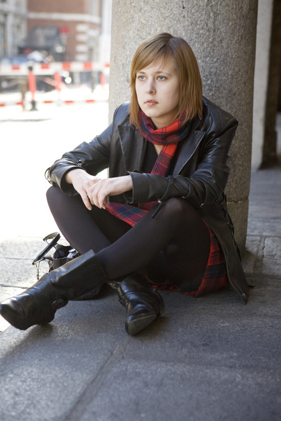 Молода жінка, сидячи на тротуар в Лондоні - Фото, зображення