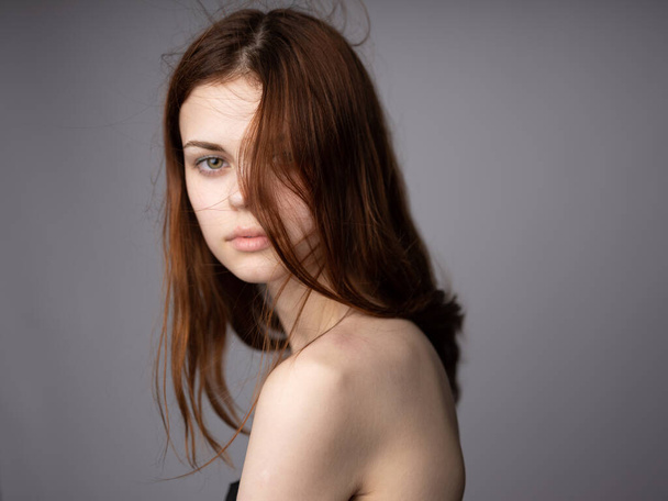 Visão lateral retrato de mulher com ombros desnudados para fundo cinza - Foto, Imagem