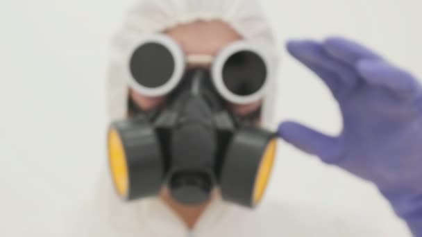 Ο άνθρωπος με στολή χημικής προστασίας σηκώνει γυαλιά. Θολή κοντινή, αργή κίνηση - Πλάνα, βίντεο