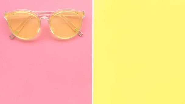 Modern fashionable sunglasses on pink and yellow background - Photo, Image