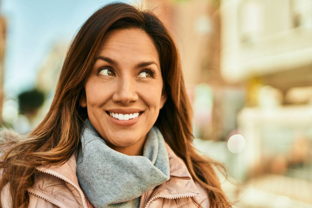 Joven mujer hispana sonriendo feliz de pie en la ciudad. - Foto, imagen