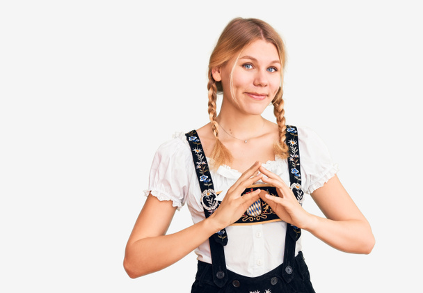 Νεαρή όμορφη ξανθιά γυναίκα φορώντας Oktoberfest φόρεμα χέρια μαζί και τα δάχτυλα σταυρωμένα χαμογελώντας χαλαρή και χαρούμενη. επιτυχία και αισιοδοξία  - Φωτογραφία, εικόνα