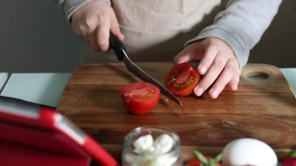 Frau kocht nach dem Tutorial des virtuellen Online-Meisterkurses und schaut auf das digitale Rezept, mit Touchscreen-Tablet, während sie zu Hause in der Küche gesunde Mahlzeiten zubereitet - Filmmaterial, Video