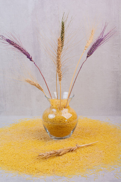 Деликатесная желтая вермишель с вазой пшеницы. Высокое качество фото - Фото, изображение