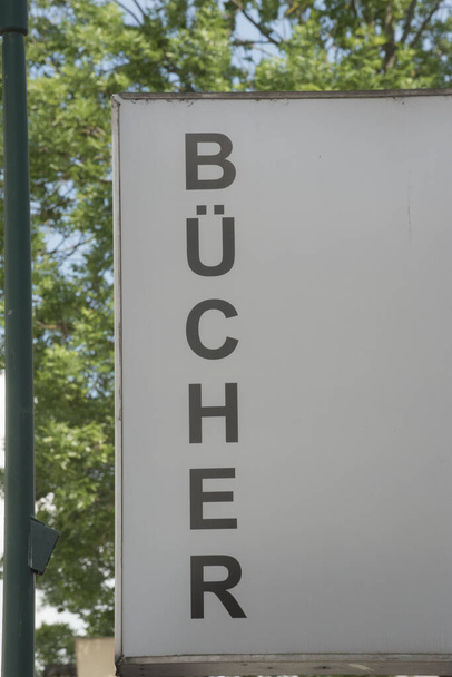 λευκό Βιβλιοθήκη (Buecherei) υπογράψει με μαύρα γράμματα, δέντρο στο παρασκήνιο - Φωτογραφία, εικόνα
