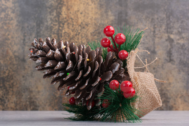 Pine cone and holly berry on white table. High quality photo - Photo, Image