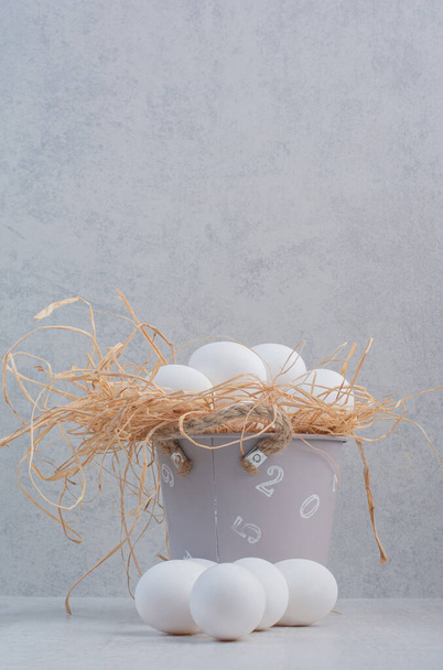 Uova fresche bianche in secchio su fondo marmo. Foto di alta qualità - Foto, immagini