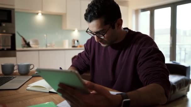 Gemengde race zakenman lezen van digitale tablet opschrijven op notitieblok  - Video