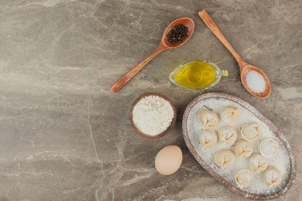 Cucharas con sal, pimienta, aceite, huevo, harina y albóndigas. Foto de alta calidad - Foto, Imagen