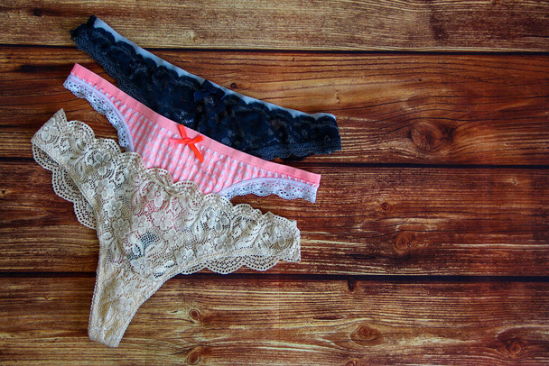 Tři krajky sexy kalhotky na dřevěném pozadí s copyspace - Fotografie, Obrázek