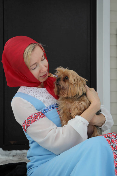 Nainen venäläisessä puvussa koira sylissään. Cosplay satu Morozko. - Valokuva, kuva