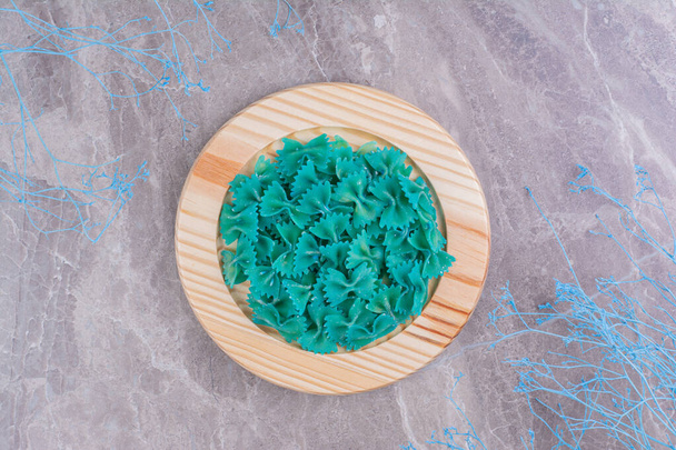 Блакитні пасти в дерев'яній тарілці на мармурі. Високоякісна фотографія
 - Фото, зображення