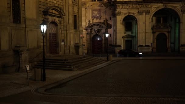 optikai zoom lámpa utcai fény a régi járdán, és a háttérben egy sötét utcában egy civil és egy rendőrautó vezet éjszaka a régi város Prága. - Felvétel, videó