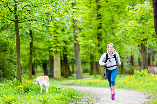 Läuferin geht mit Hund im Sommerpark spazieren - Foto, Bild