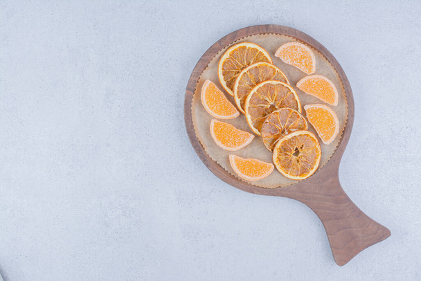 Rodajas de naranja secas y mermeladas sobre tabla de madera. Foto de alta calidad - Foto, Imagen