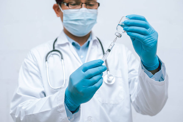 Médico, enfermero, científico mano en guantes azules que sostienen la gripe, sarampión, coronavirus, covid-19 vacuna enfermedad preparación vacuna inyección, medicina y el concepto de drogas. - Foto, imagen